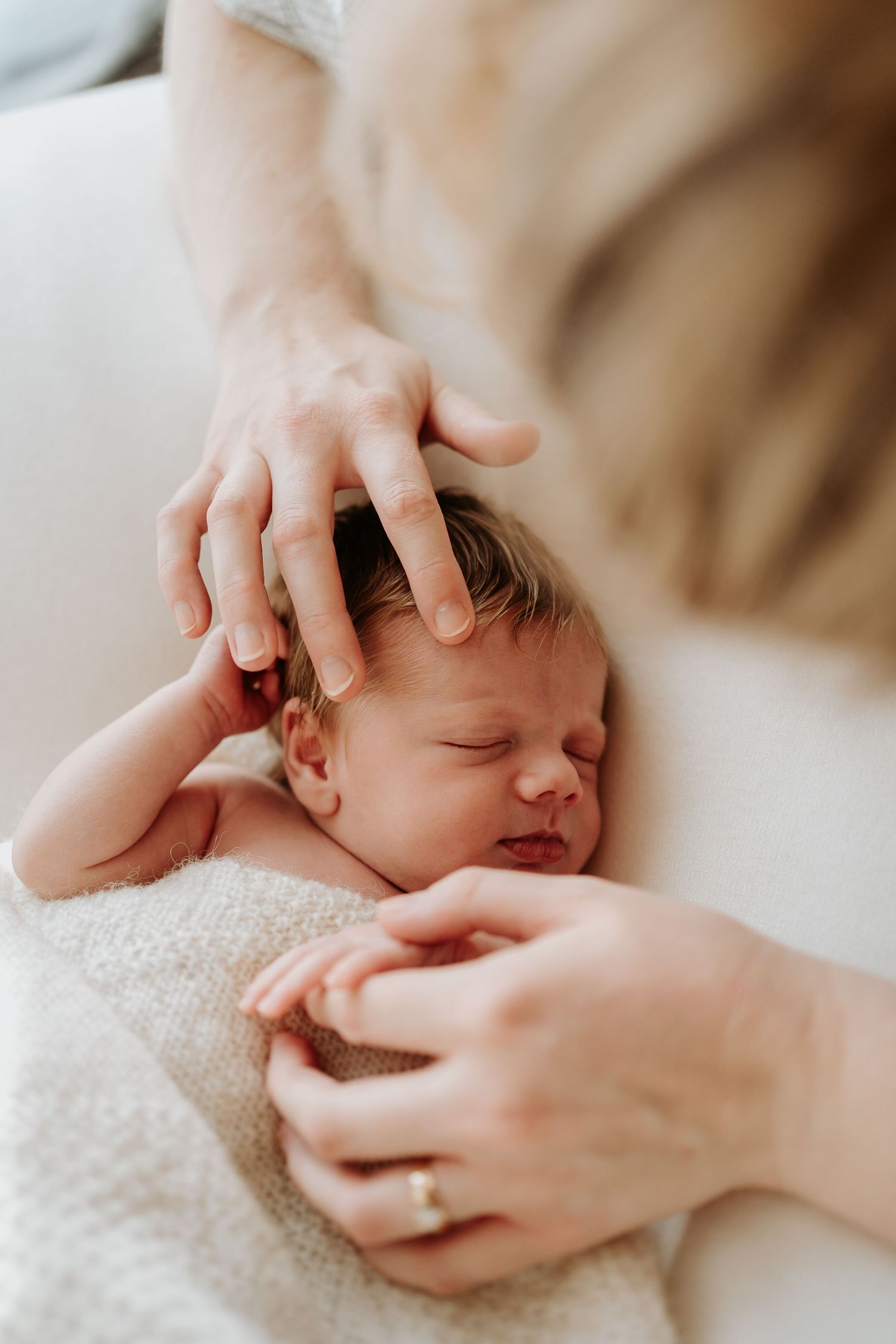 Newborn baby being gently settled during a natural in-home newborn photography session