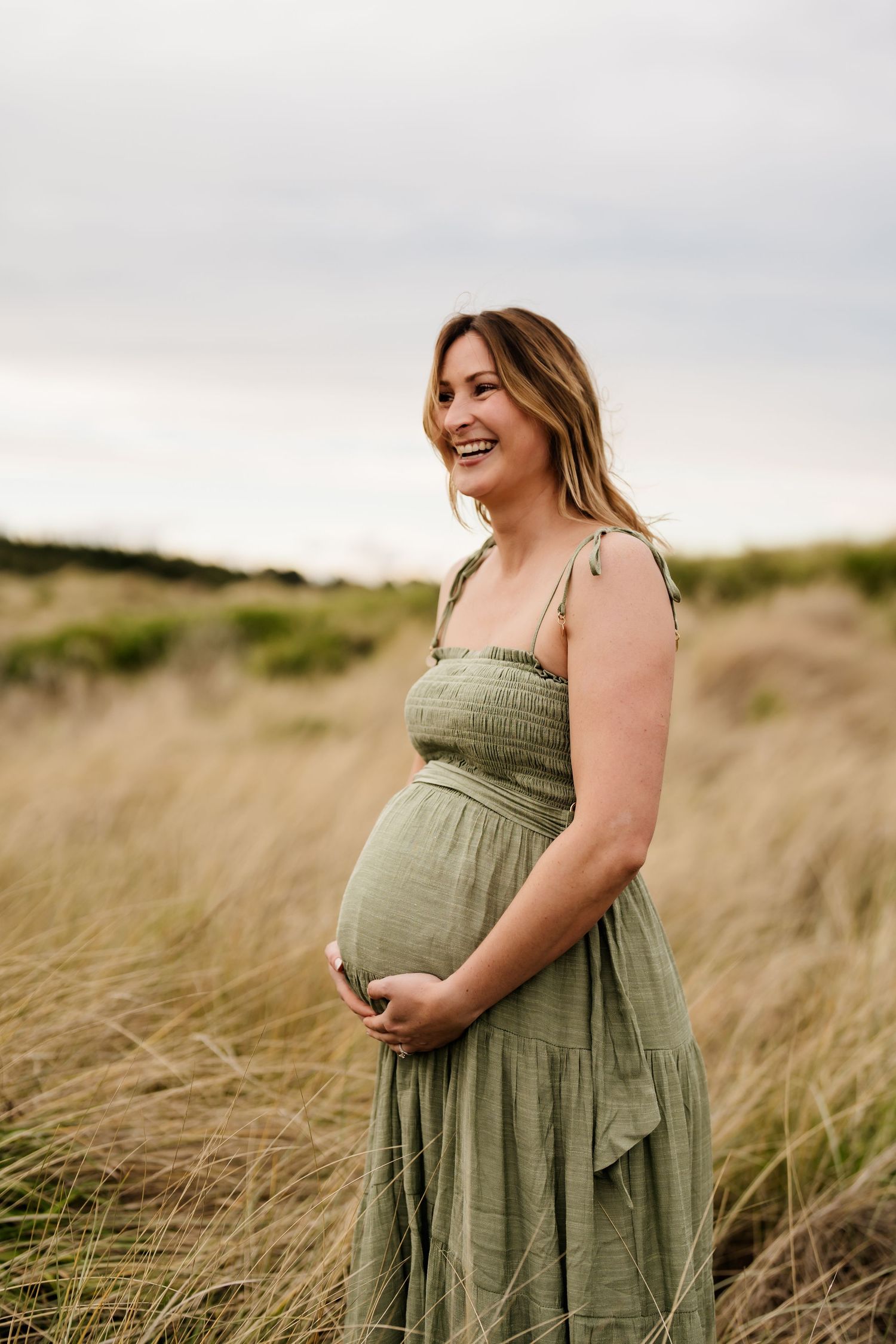 Pregnant woman in a green dress during an outdoor maternity photography session in Christchurch