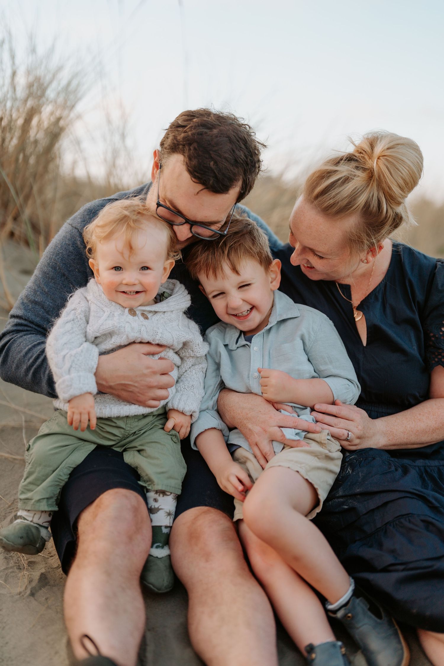 A family laughing on the beach at a photo session by a Christchurch family photographer