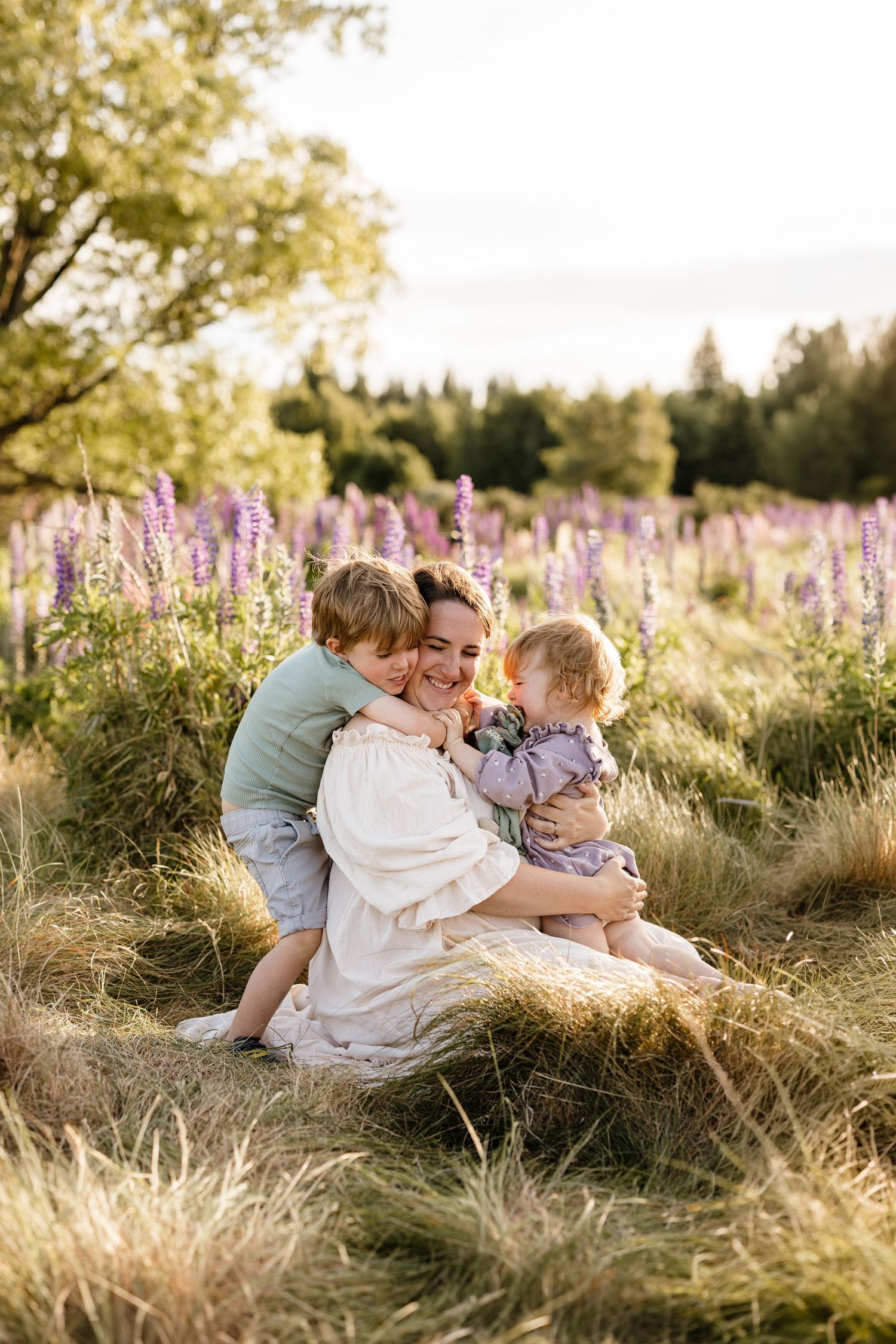Mum cuddling her two young children during an outdoor family photography session in Christchurch