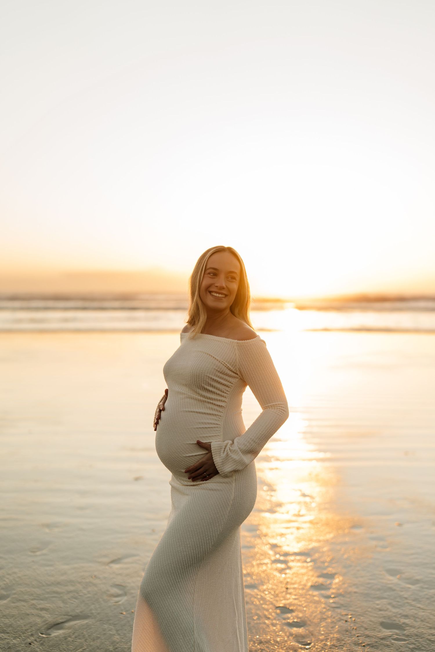 A mother to be on a beach at sunrise