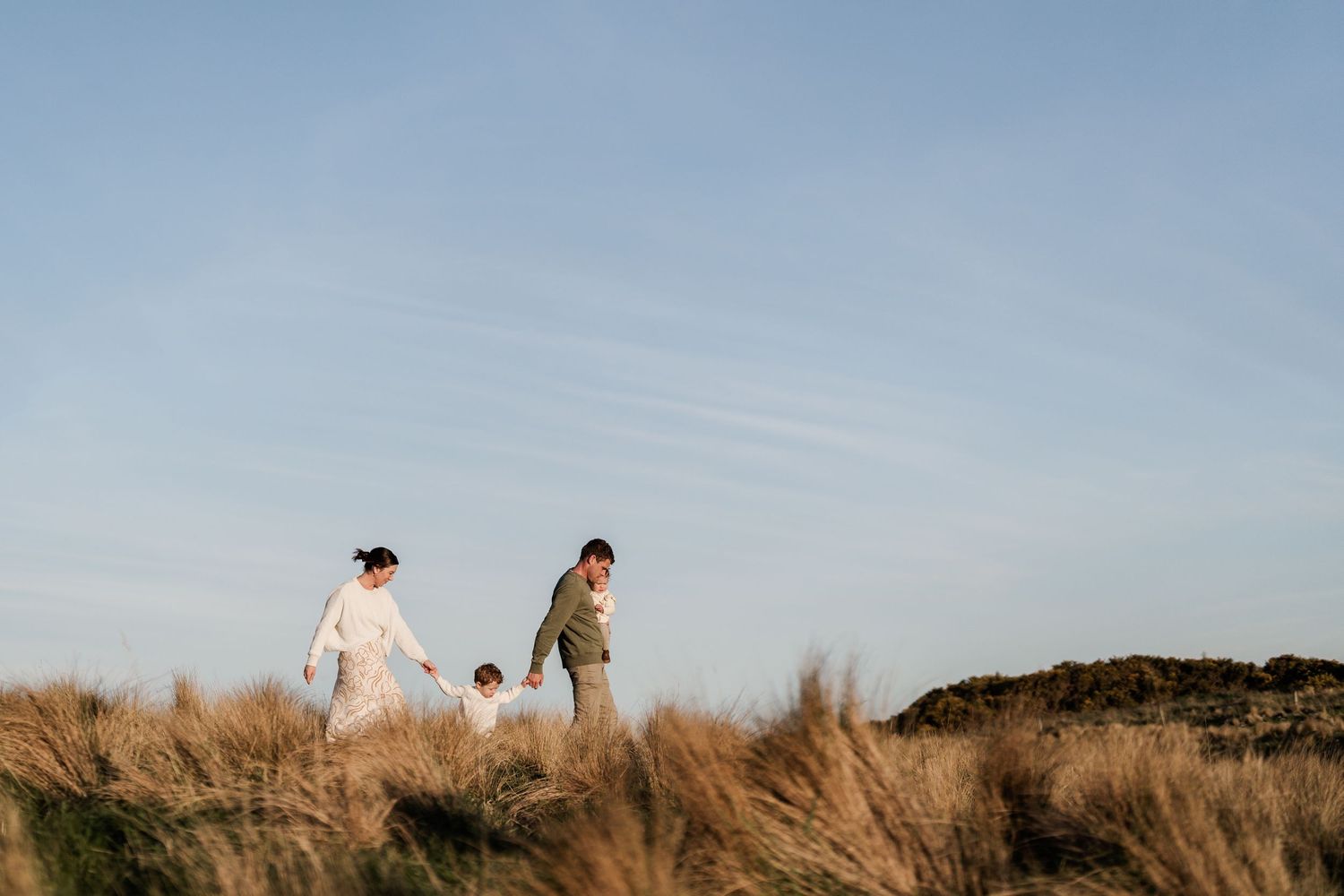 Family walking together through Port Hills during an outdoor family photo session in Christchurch