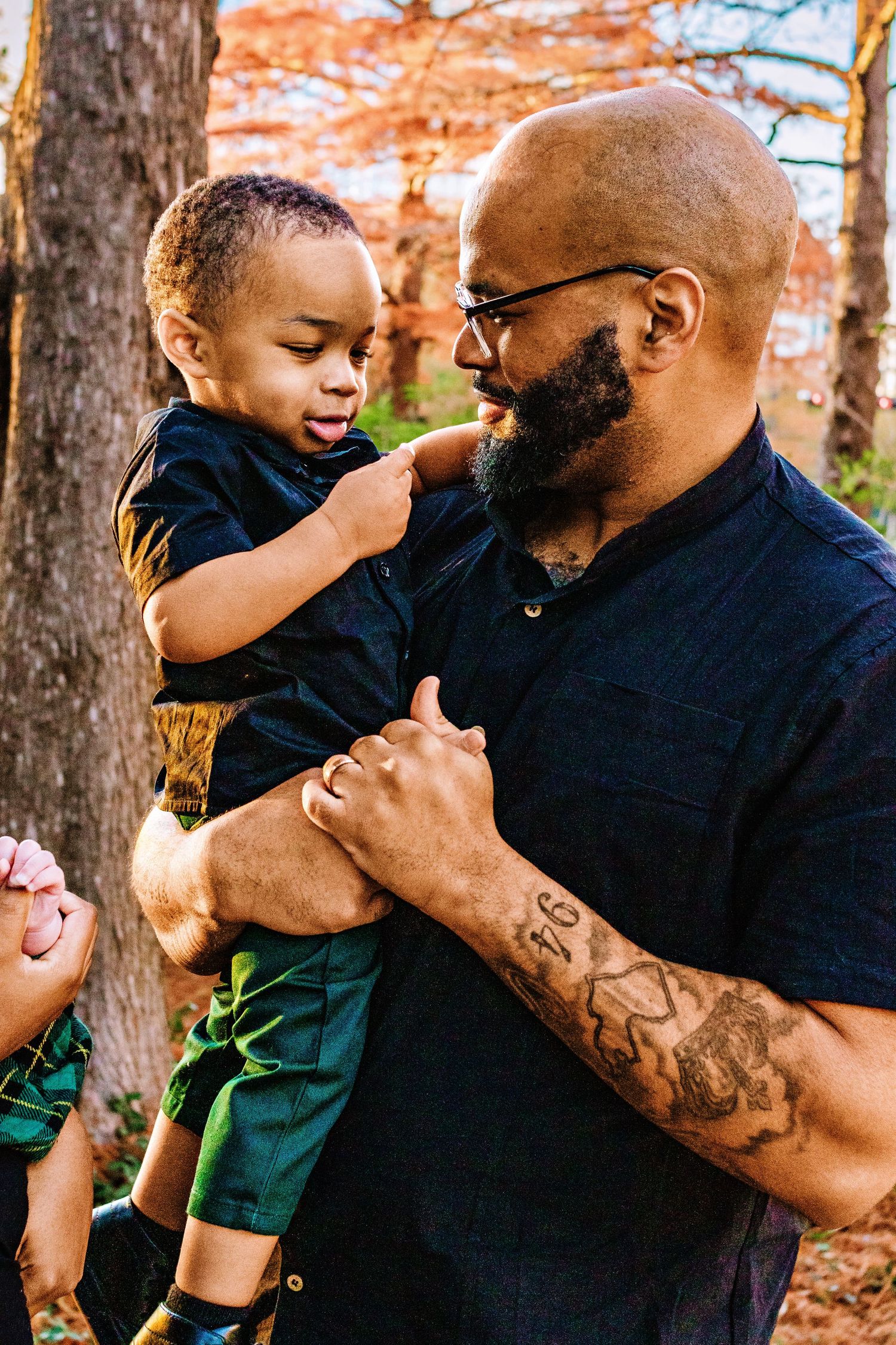 A tender moment between parent and child playing together in a wooded area during autumn.