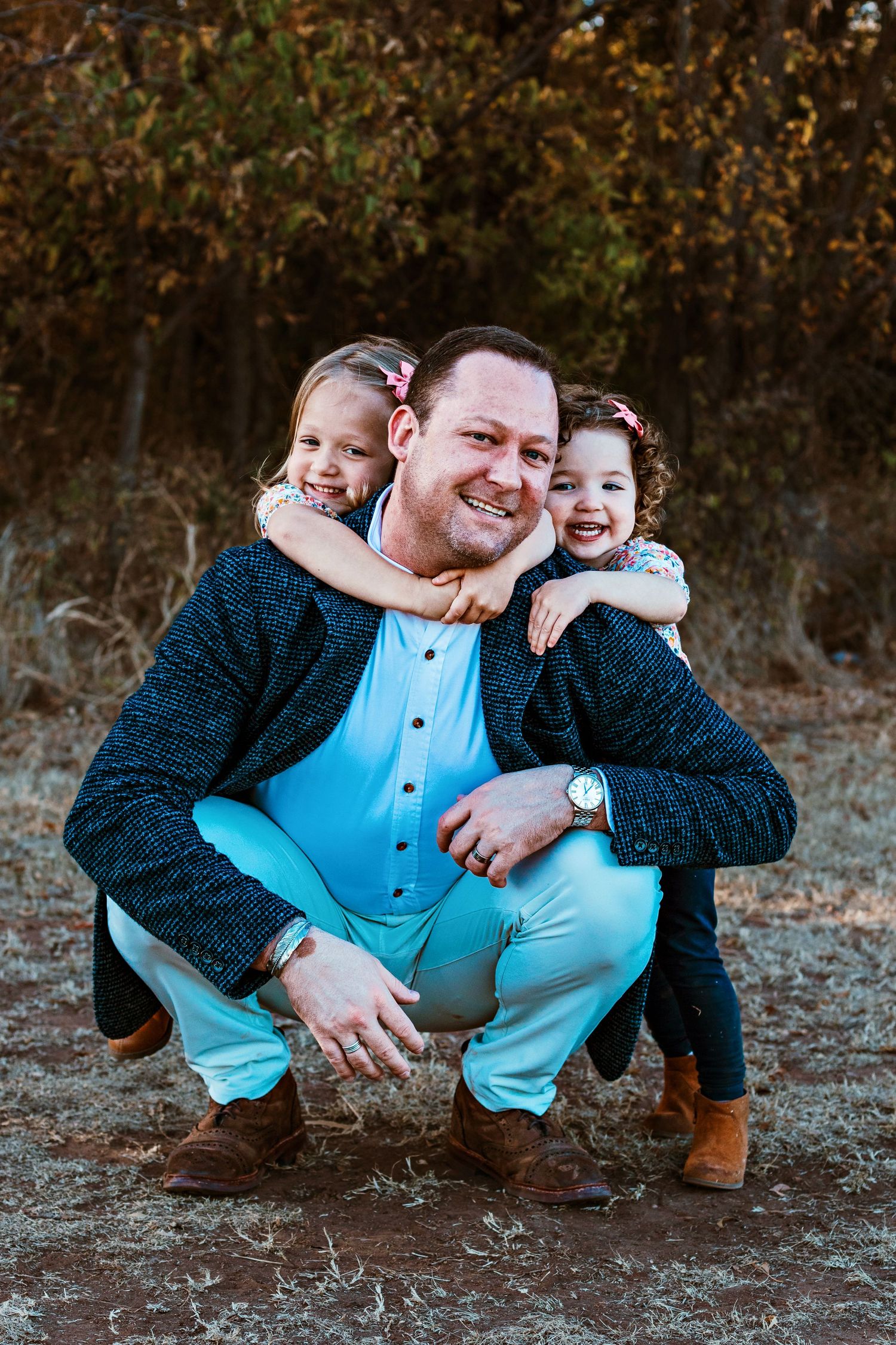 Playful family photo series showing close bonding moments on the ground outdoors.