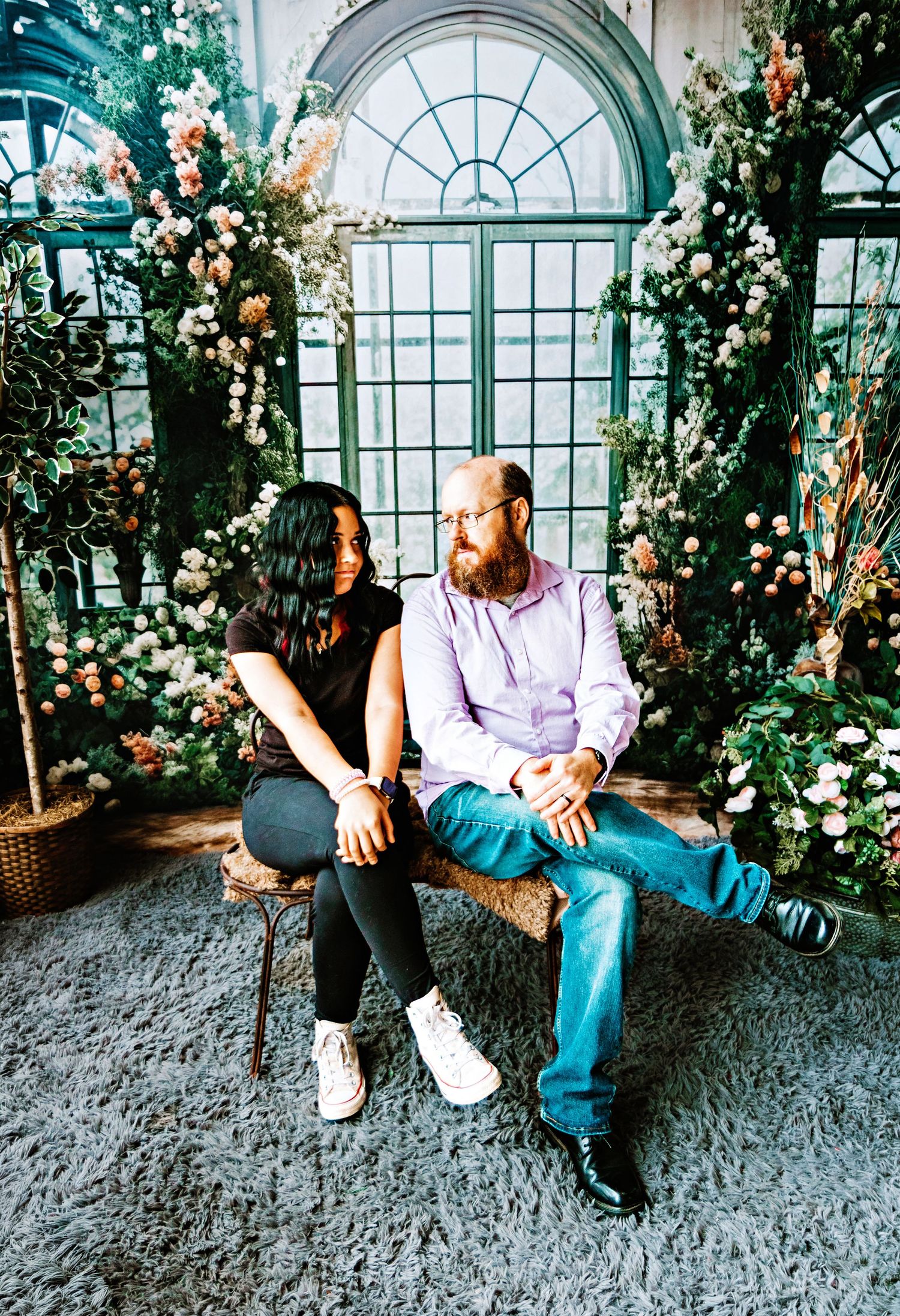A series of four photos showing a couple sitting together in a romantic greenhouse setting with arched windows and climbing roses.