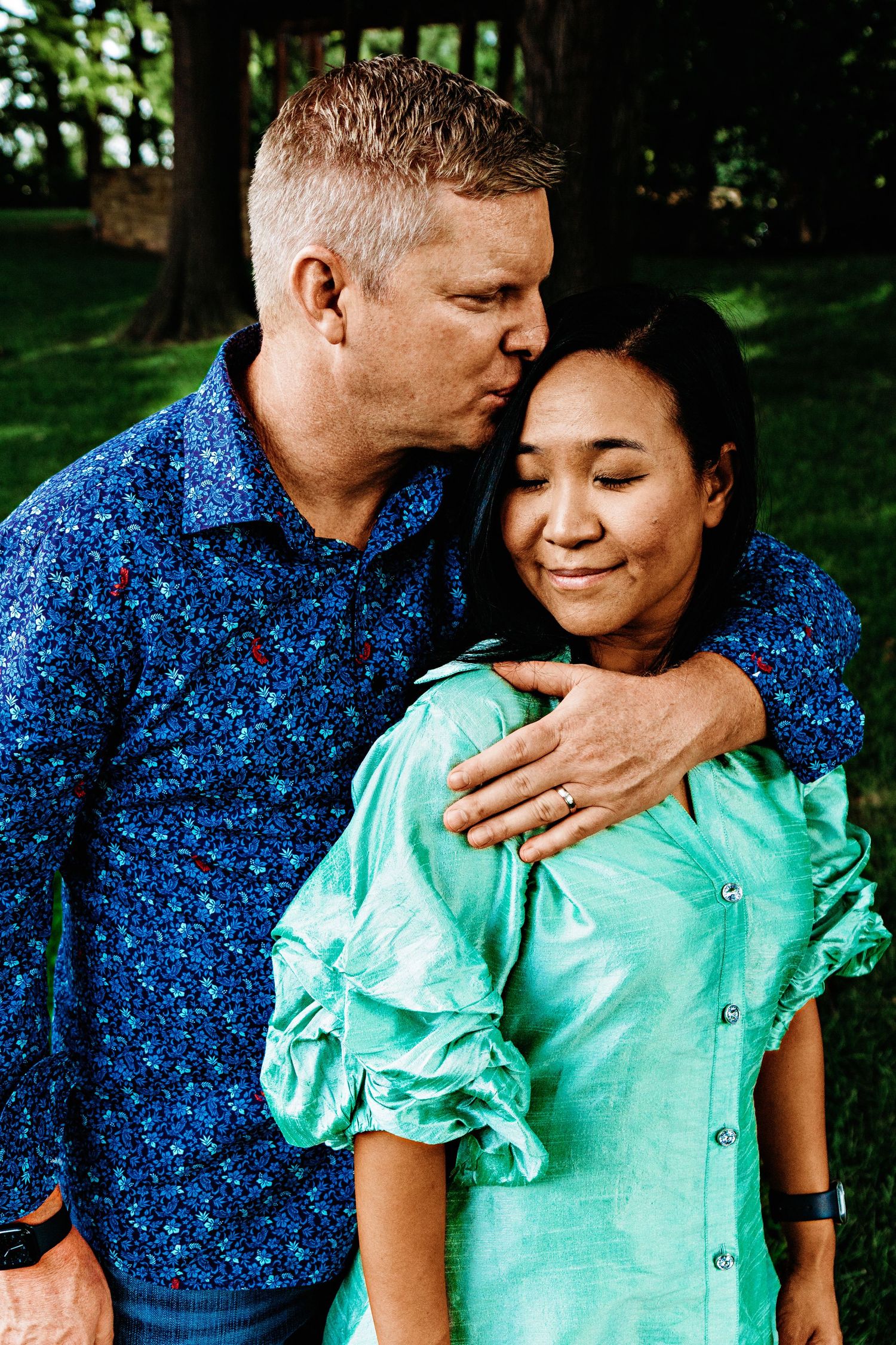A couple in blue and mint green outfits share intimate moments in a series of romantic outdoor photos.