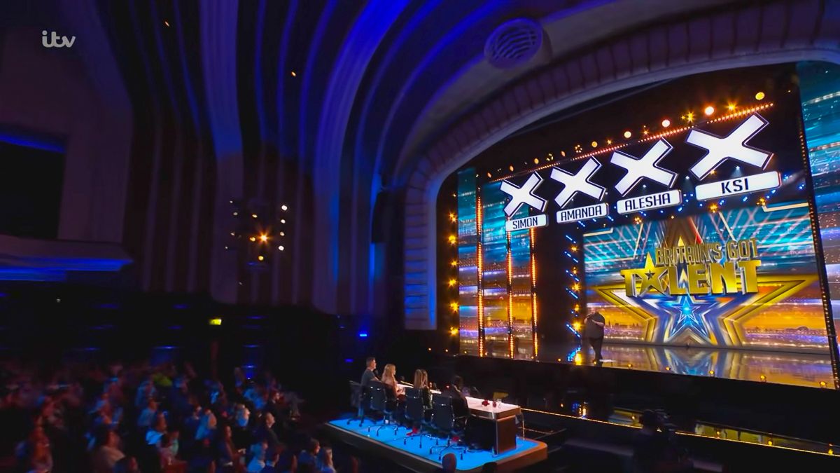 Britain's Got Talent stage with four X marks displayed on screen inside a grand theater with audience and judges panel.