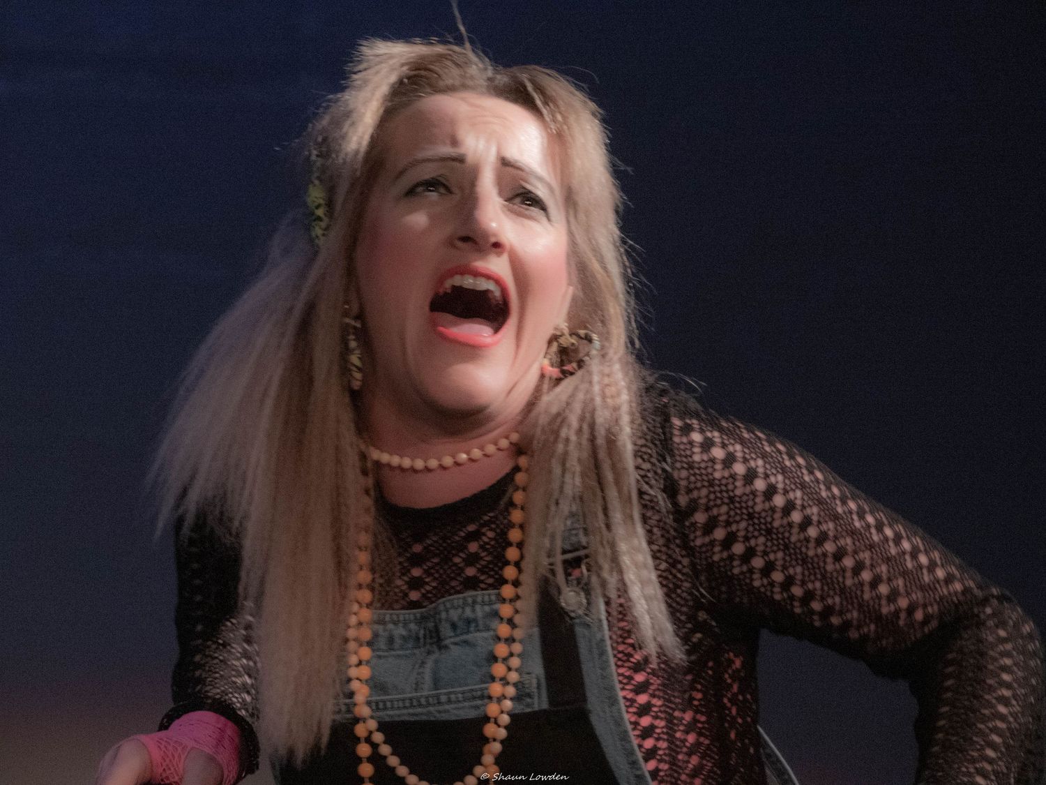 A dramatic stage performance with dark lighting and expressive movements.