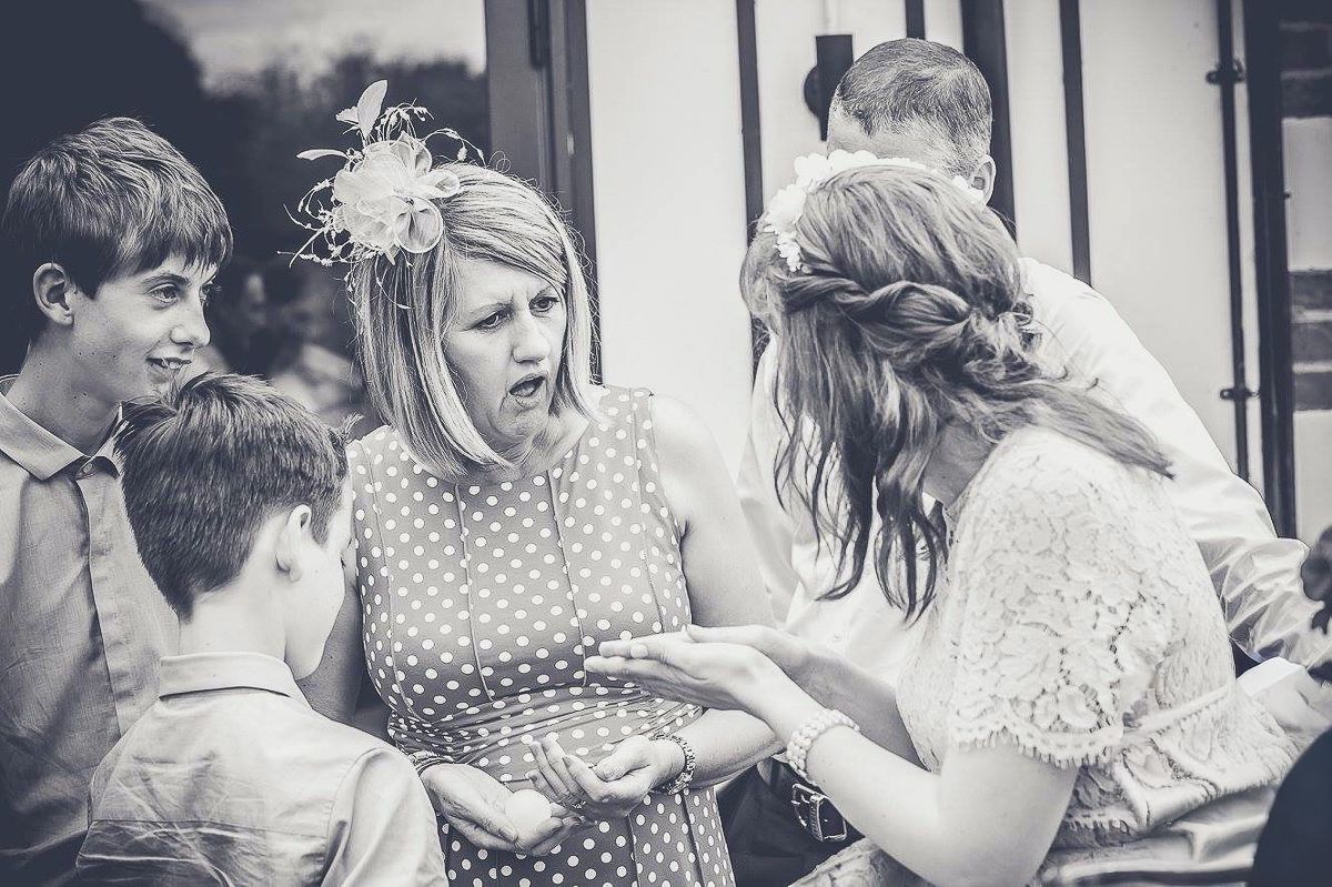 Wedding party members laughing and playing games during casual reception moments.