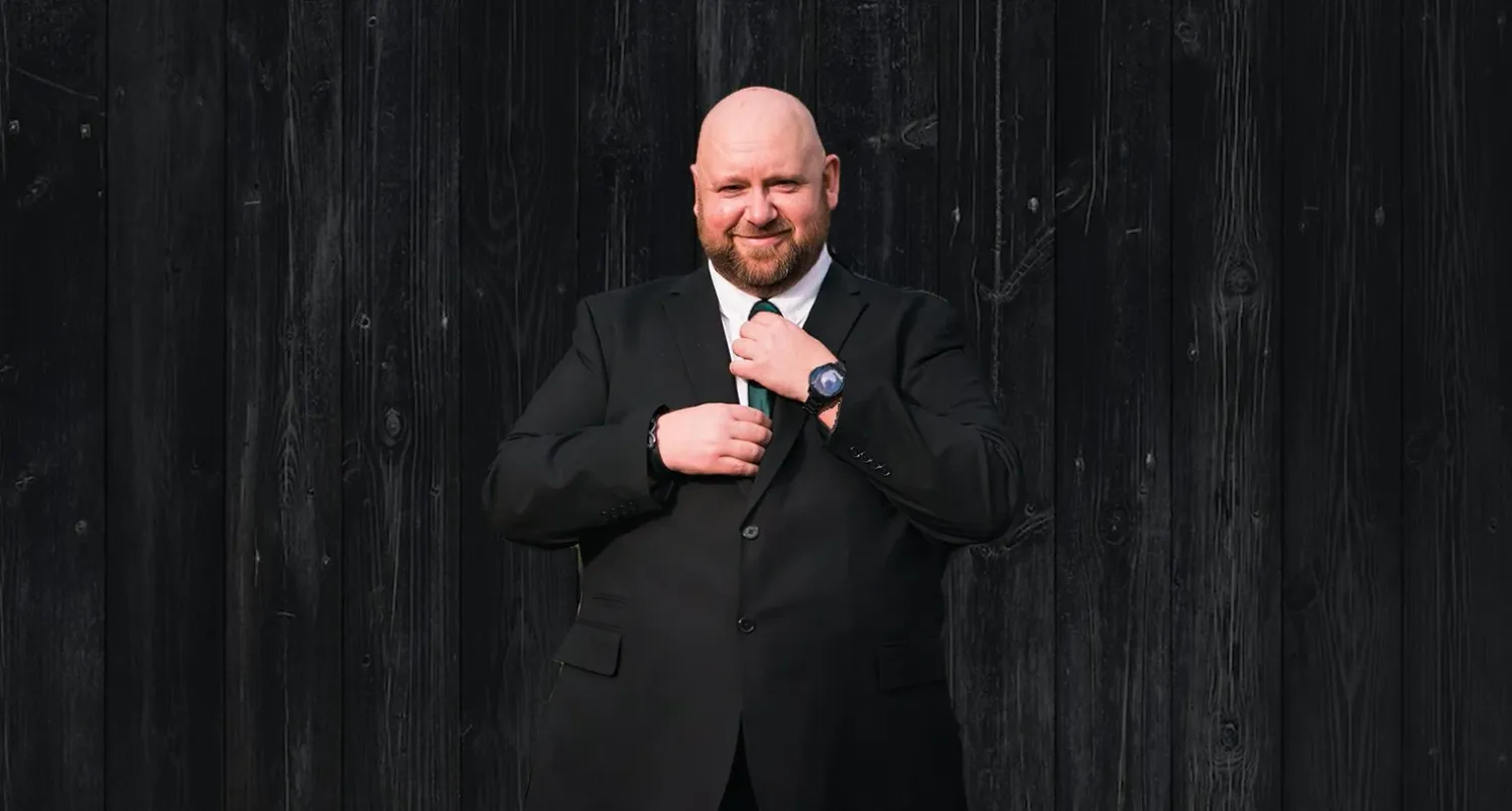 Professional entertainer performing at a wedding reception against a dark background.