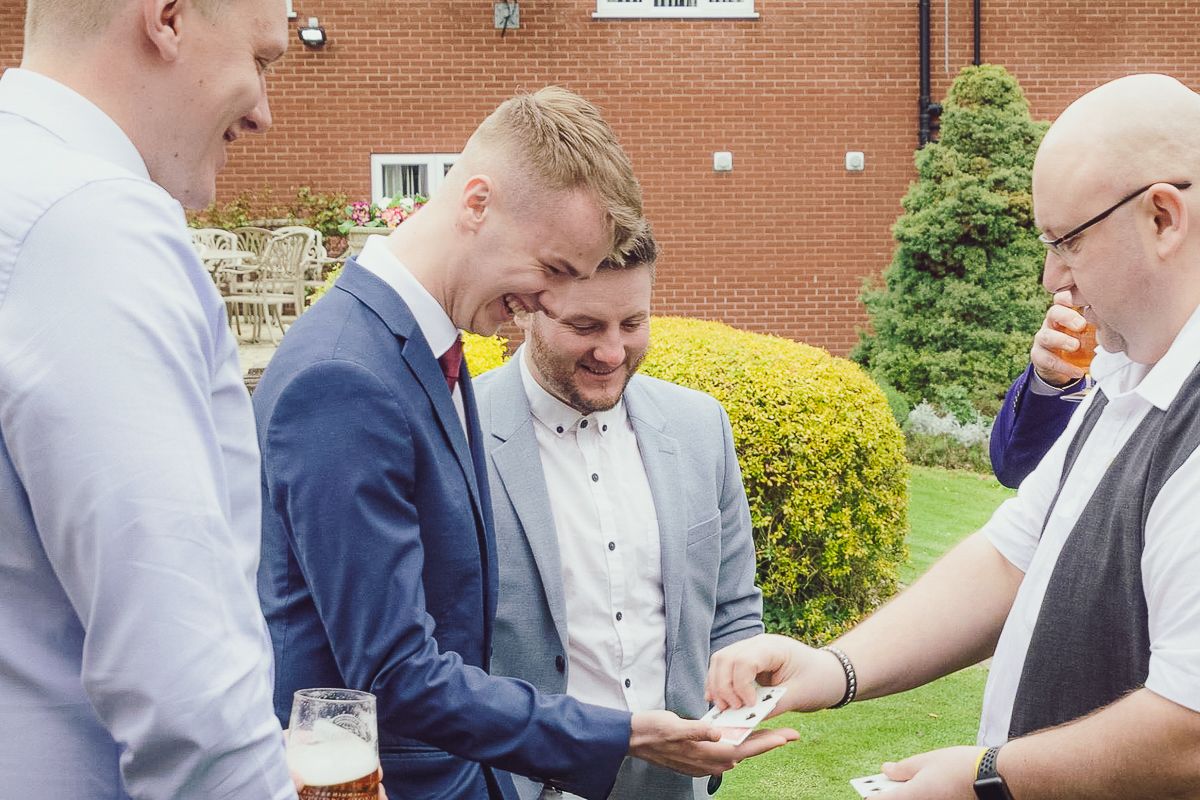 Group gathered outdoors examining something with amused expressions.