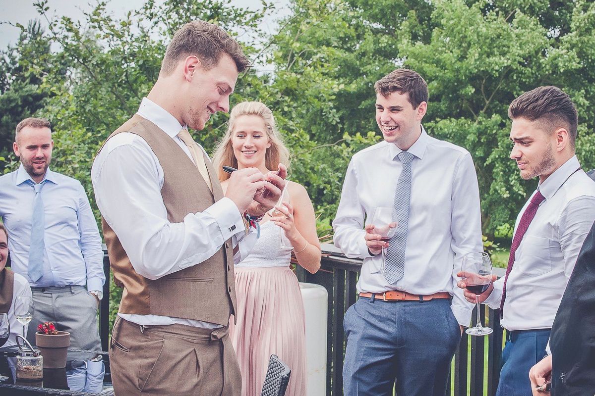 Wedding party and guests mingling during outdoor summer reception activities.