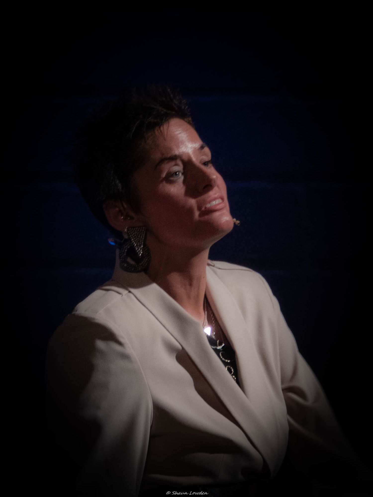 A dramatic low-light stage performance with moody atmospheric lighting.