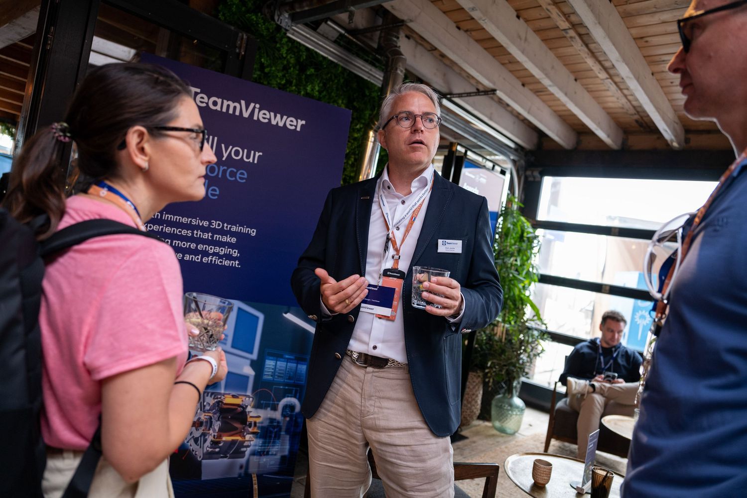 Business networking event with people engaged in conversation under indoor lighting.