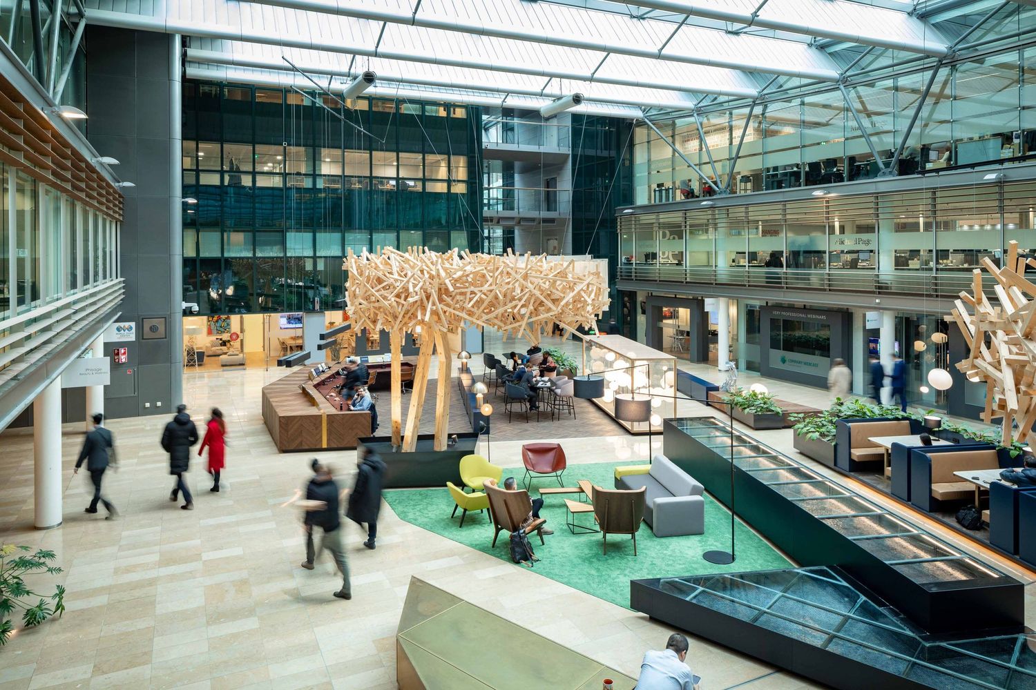 Modern office space features open layout with glass walls, collaborative seating areas and natural lighting throughout.