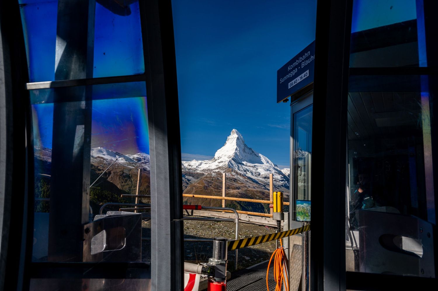 View of snow-capped Matterhorn through window frames of mountain lodge.