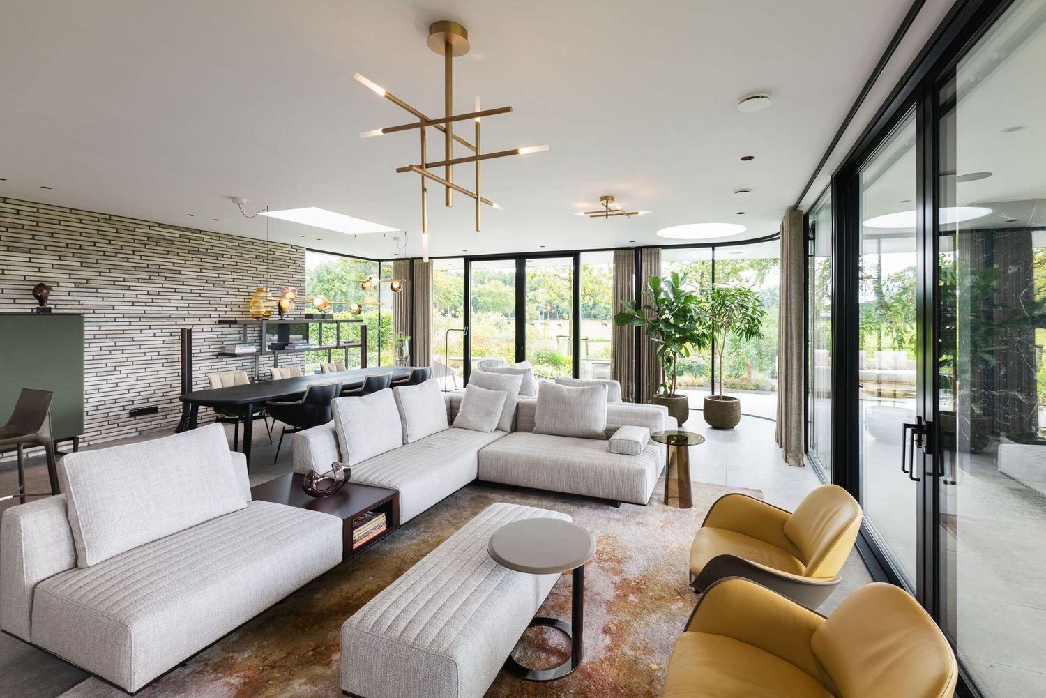 Modern luxury living room with white sectional sofa, yellow accent chairs, grand piano and floor-to-ceiling windows.