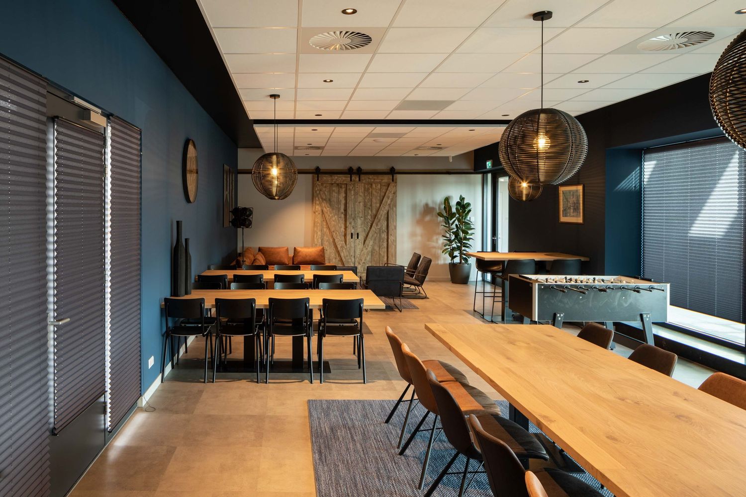 Modern office space with wooden tables and pendant lighting features sleek minimalist design and industrial elements.