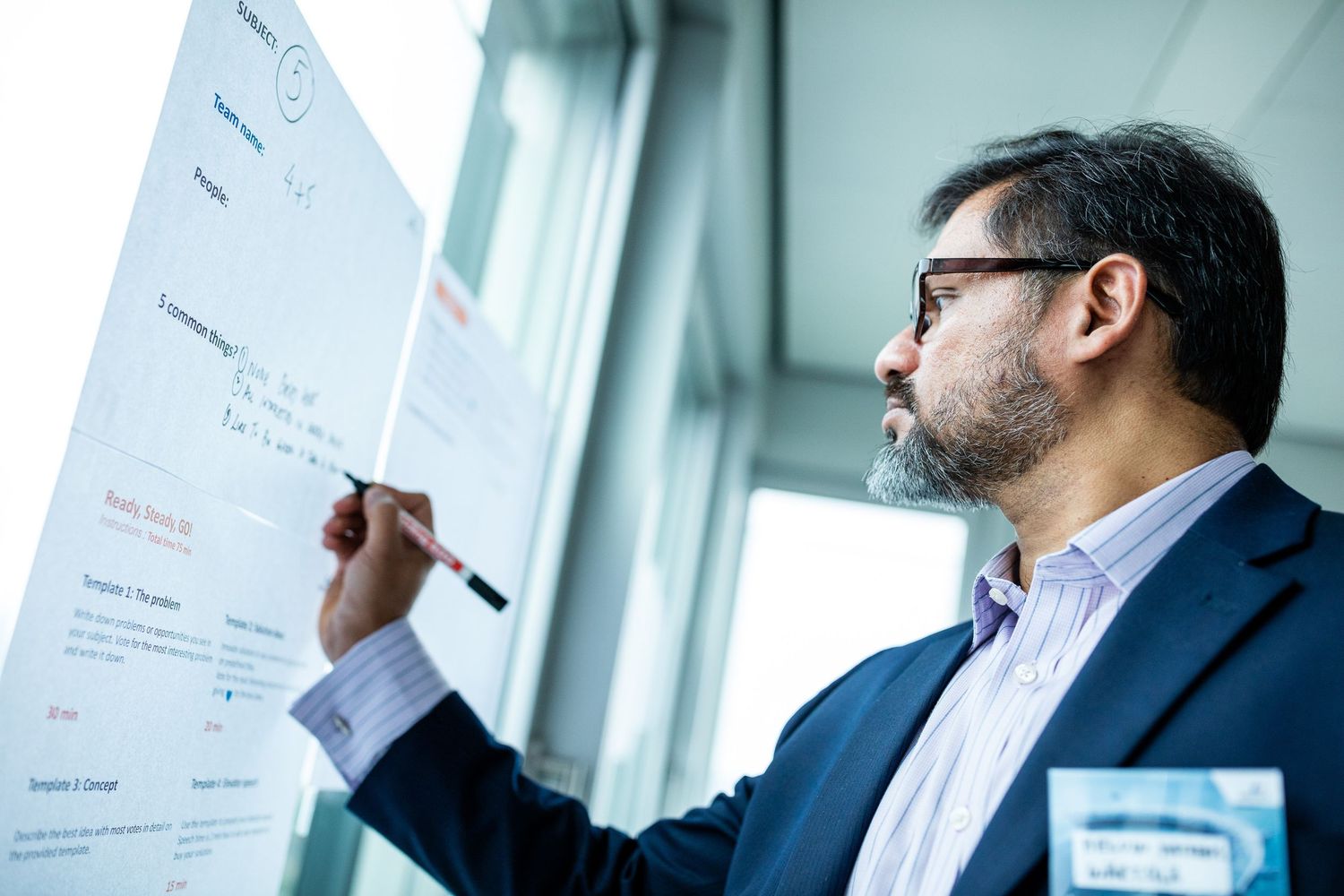 Business team reviews documents and charts during a collaborative meeting in a conference room.