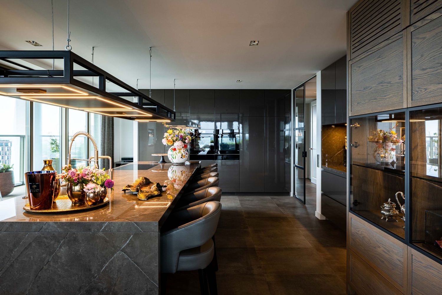 Contemporary open-concept living space with dark walls, sleek lighting fixtures, and minimalist furniture design.