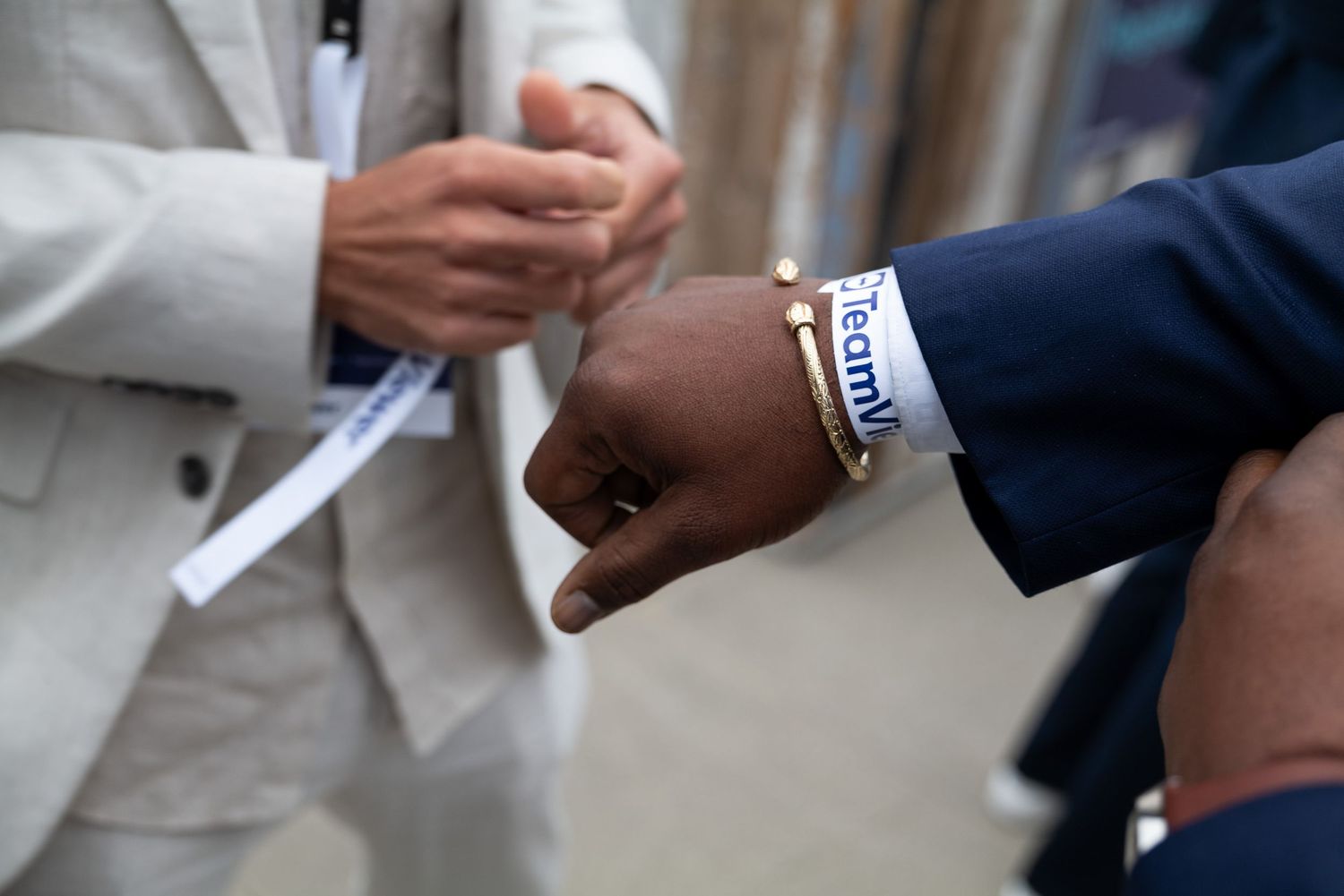 Close-up of hands wearing luxury watches during a business interaction.