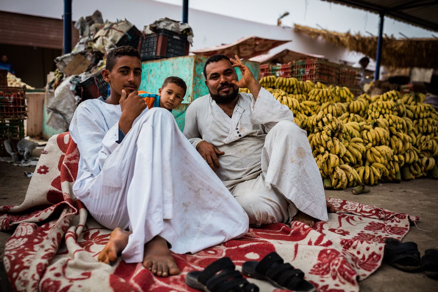Market vendors with fresh produce and bananas displayed at local bazaar.
