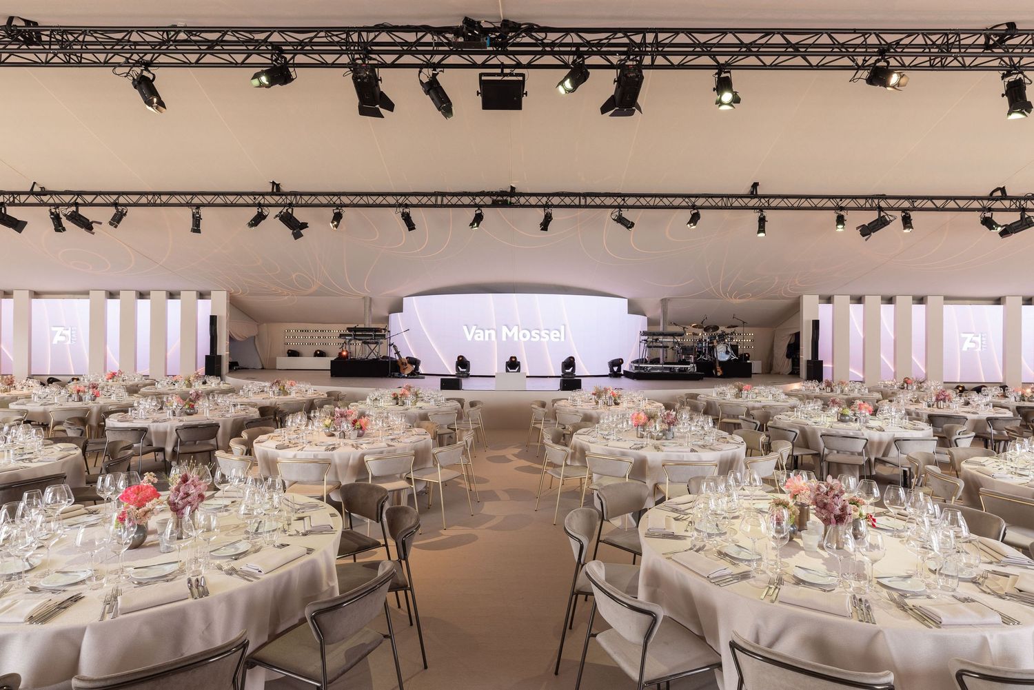 Elegant wedding reception venue setup with white tablecloths and chairs in a spacious banquet hall.
