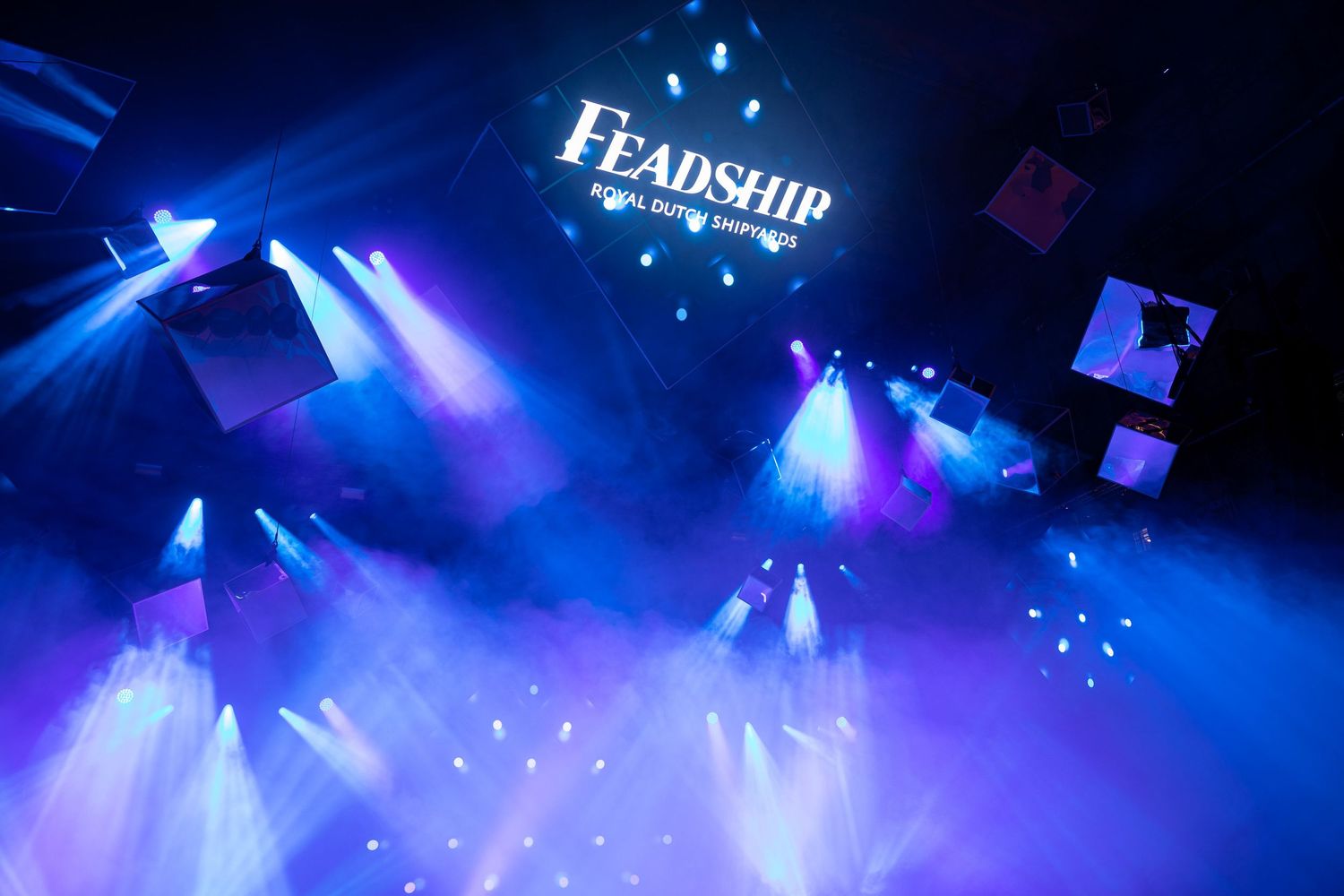 Colorful blue and purple stage lighting effects create a dramatic atmosphere during a performance.