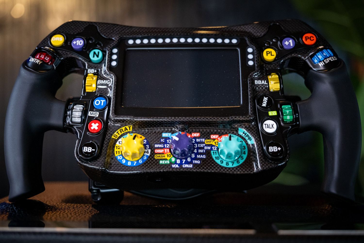 Close-up of illuminated control panel with colorful LED buttons and displays.