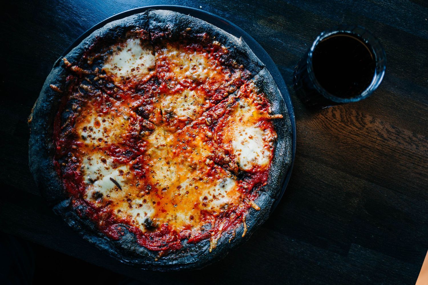 Cooking process of a bubbling cheese and tomato casserole in a cast iron skillet showing various stages of preparation.