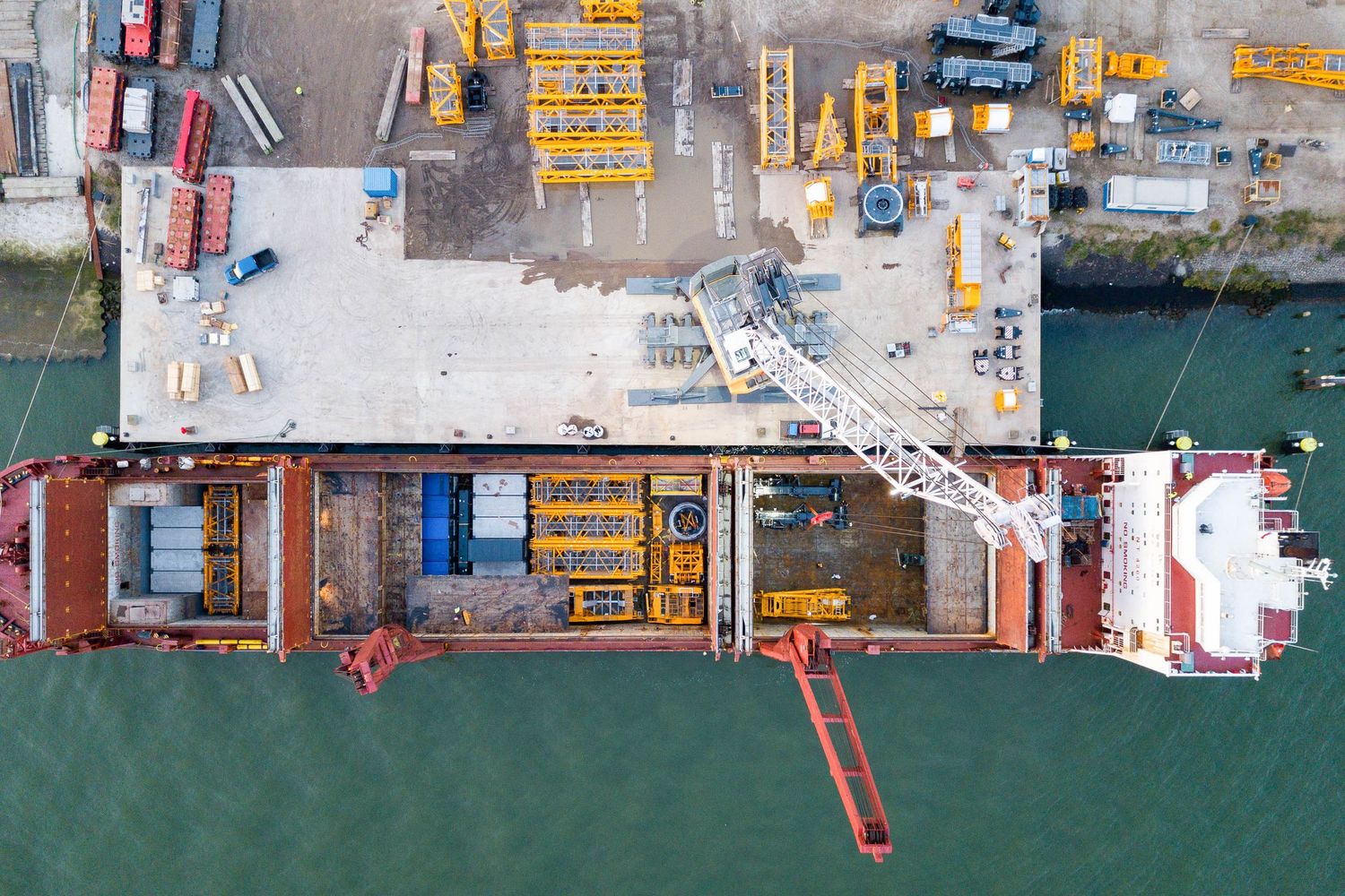Aerial view of port facility showing layout of construction equipment and storage areas.