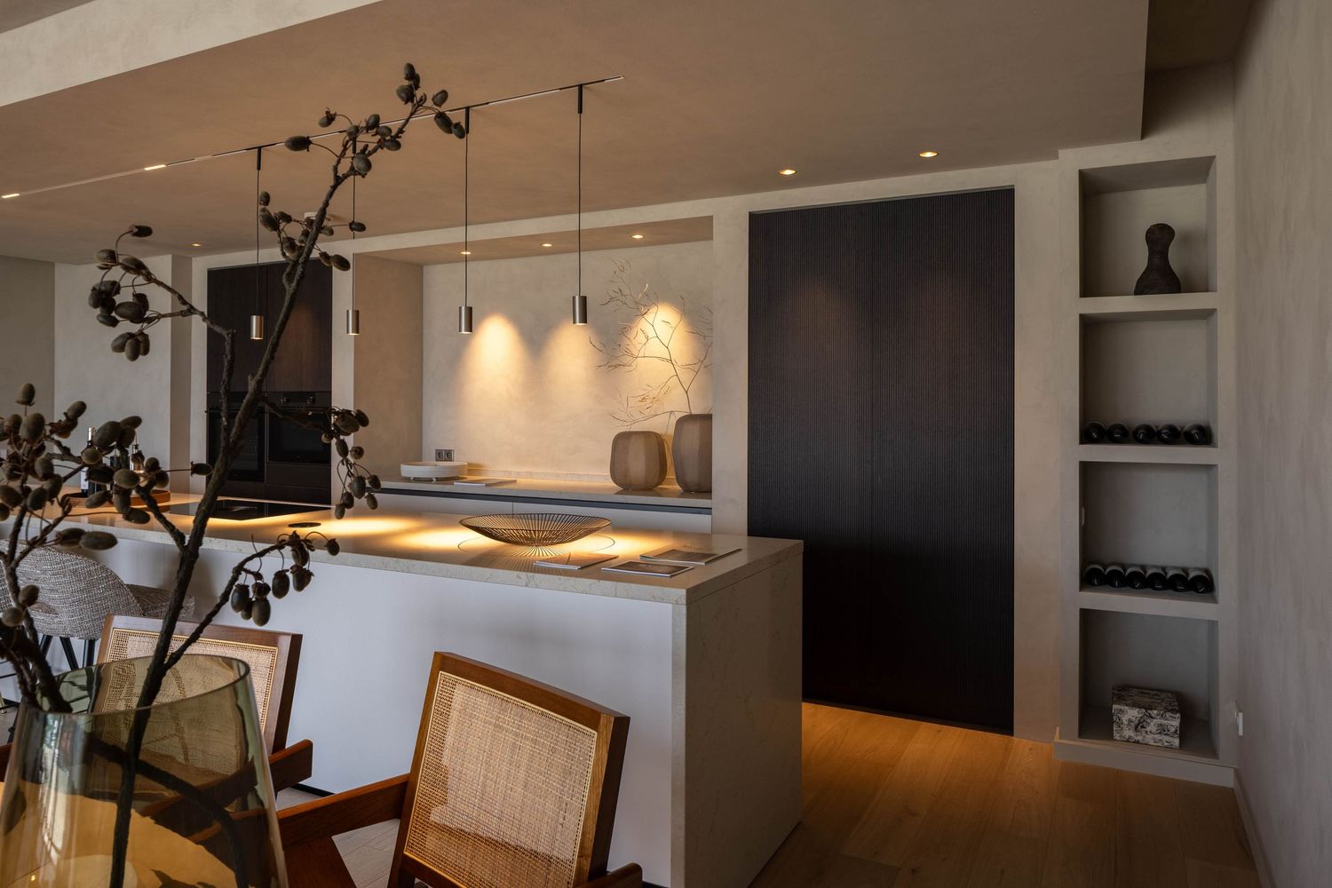 Modern open concept living room with dark accent wall, pendant lighting, and minimalist furnishings creates elegant ambiance.