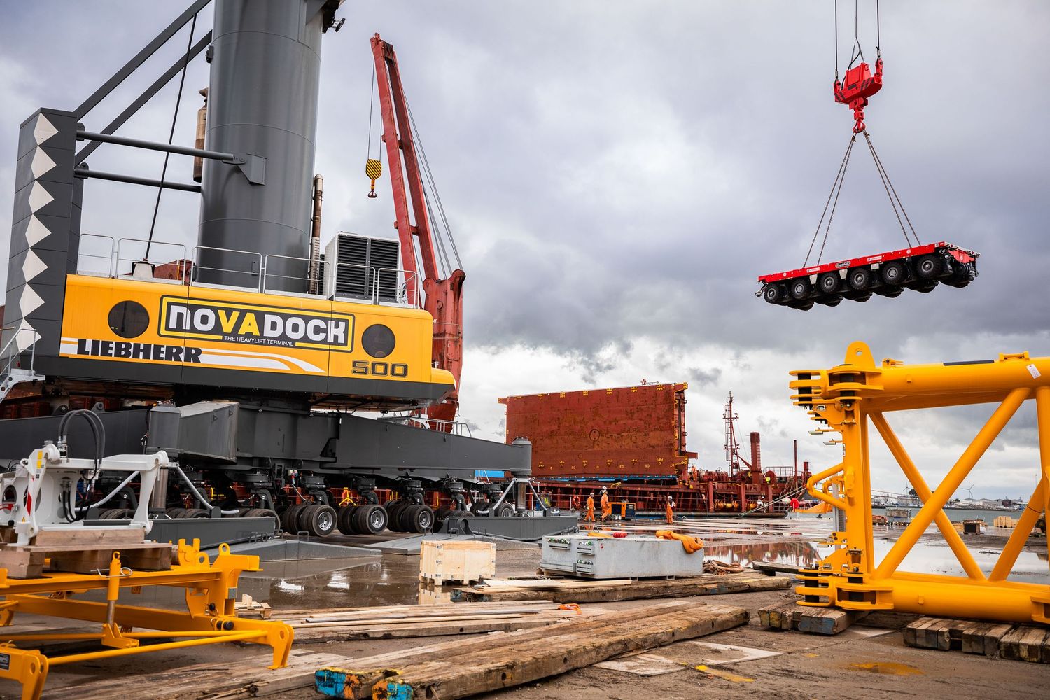 Industrial cranes lifting and positioning heavy equipment at a construction dock.
