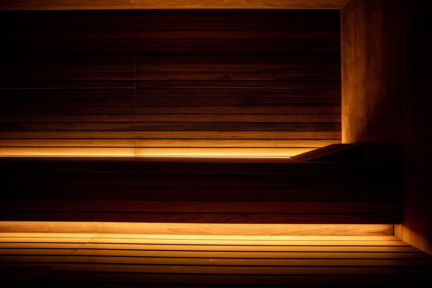 A series of seven dark wood panels with glowing orange LED strip lighting along their edges creates a modern architectural detail.