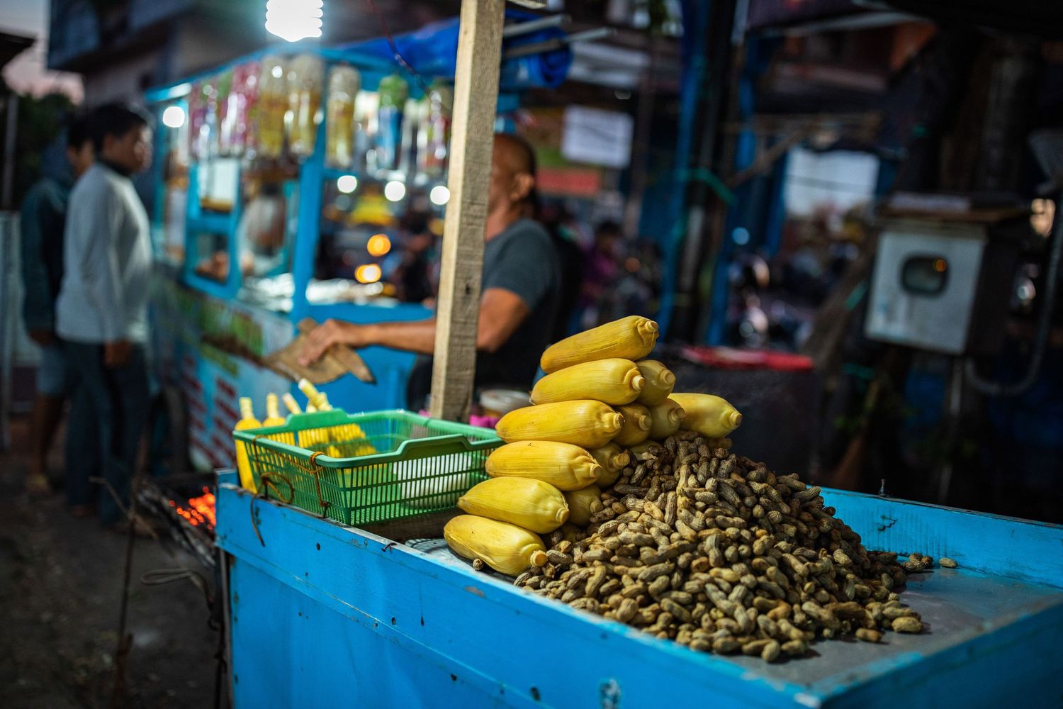 Fresh tropical fruits and produce displayed at a local market stall with bright blue accents.