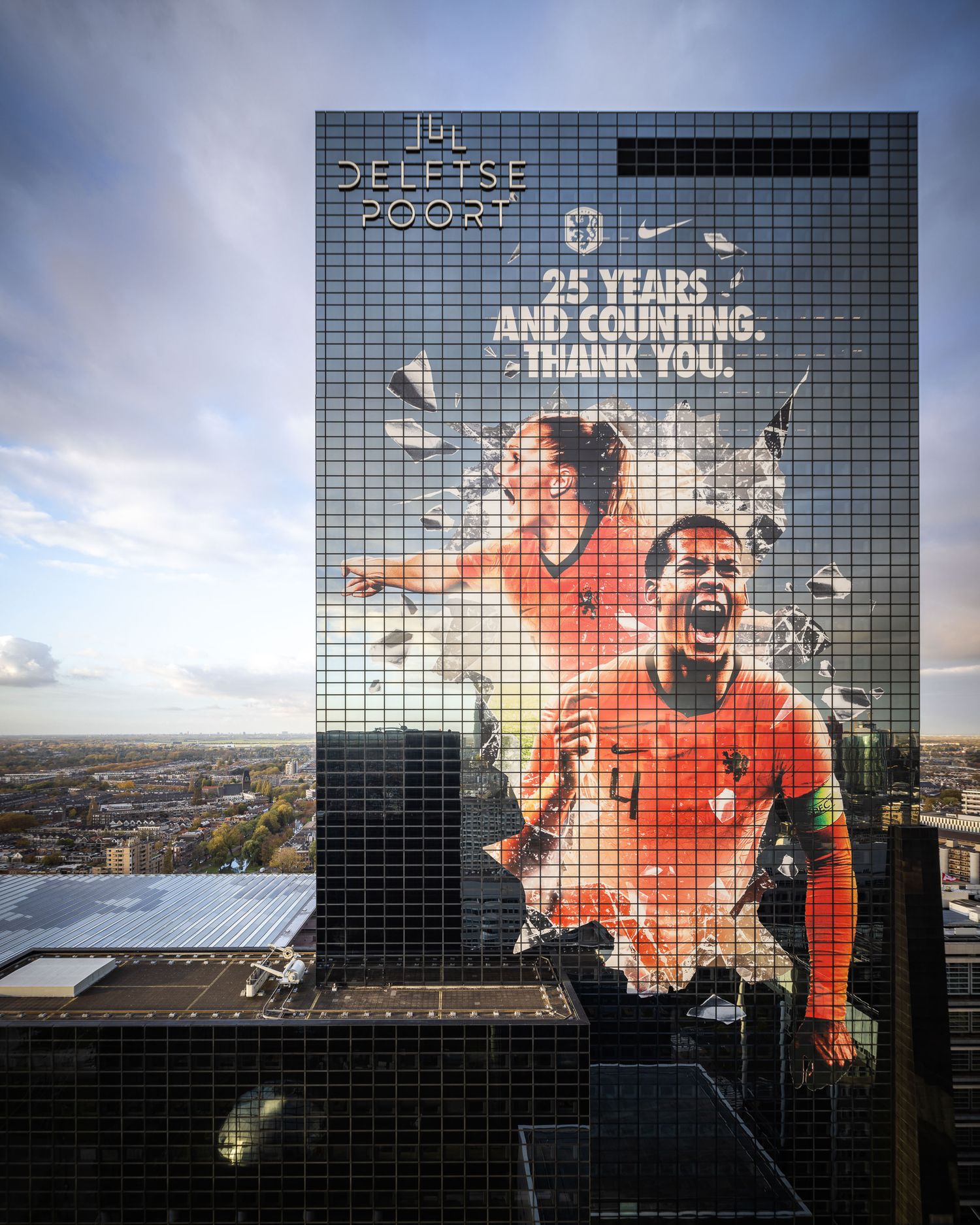 Nike mural on Delfste Poort building celebrating 25 years, featuring two soccer players in orange Dutch national team jerseys.