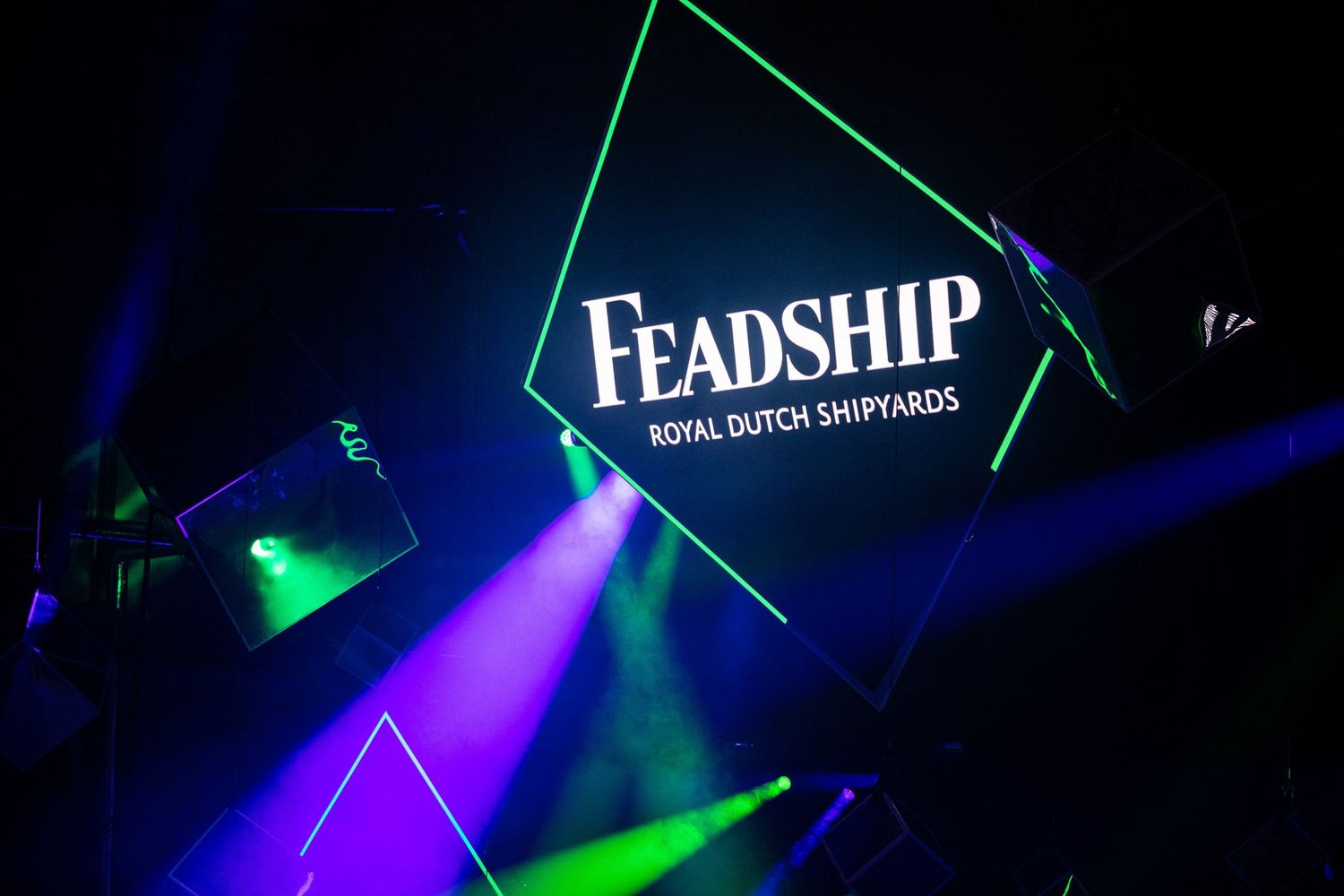 Green and blue laser lights illuminate a dark nightclub with the word 'Leadship' glowing in white text.