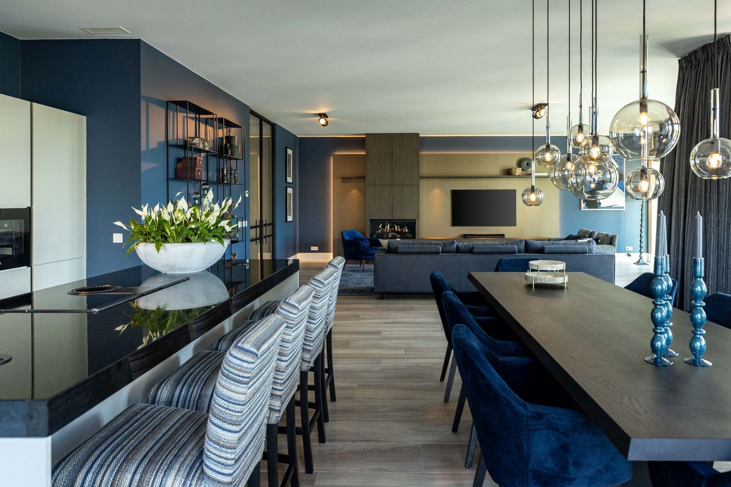 Modern blue and gray interior design featuring pendant lights and sleek furniture in an open concept living space.