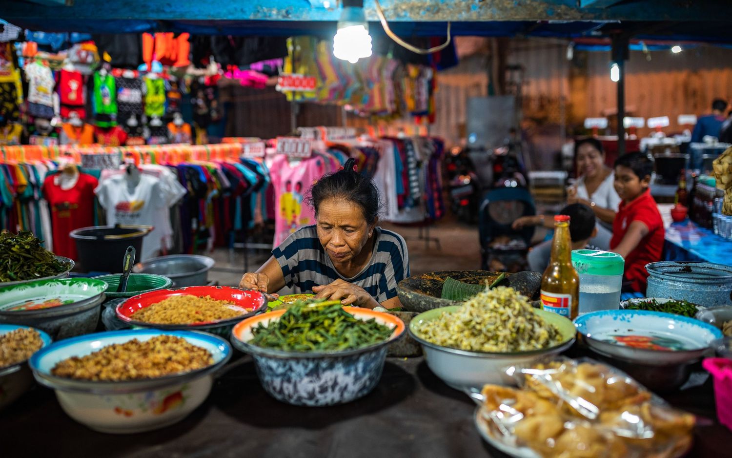 Colorful array of traditional Asian street food dishes displayed at a bustling night market.