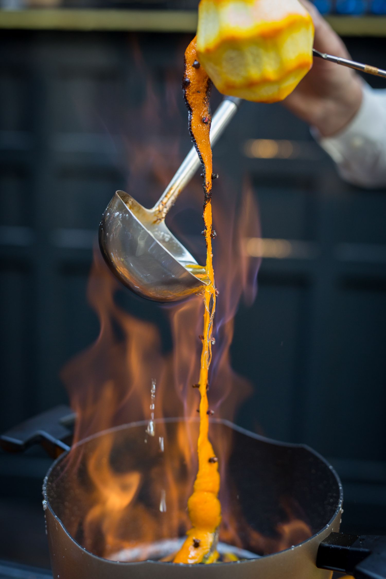 Dramatic sequence of flaming food preparation in a professional kitchen.