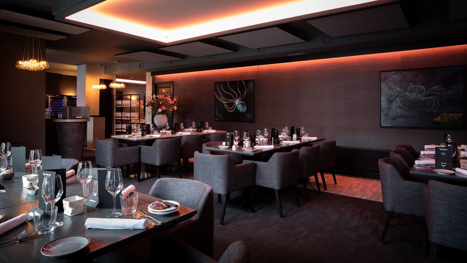 Modern restaurant interior with red accent lighting and contemporary dining setup.
