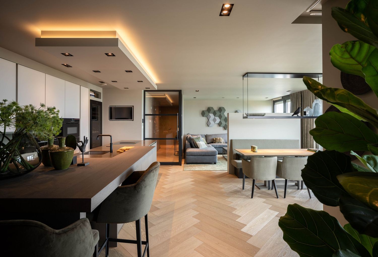 Modern apartment interior with herringbone wood floors, LED ceiling lights, and lush indoor plants by dining area.