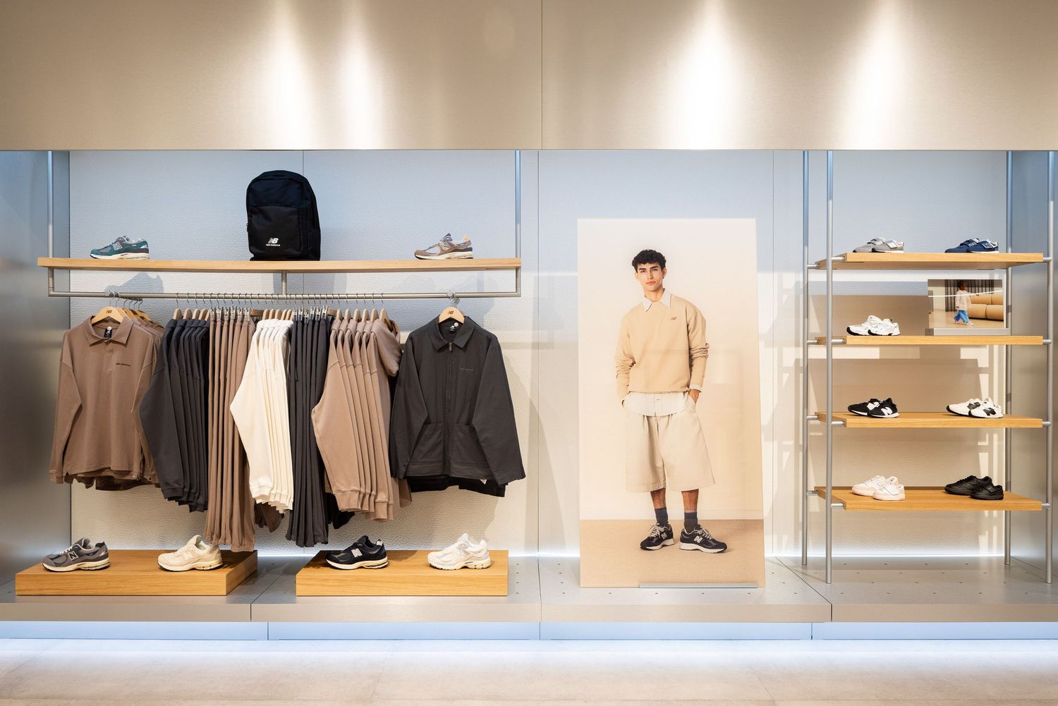 Retail display showing minimalist wooden shelving with shoes and clothing in modern store layout.