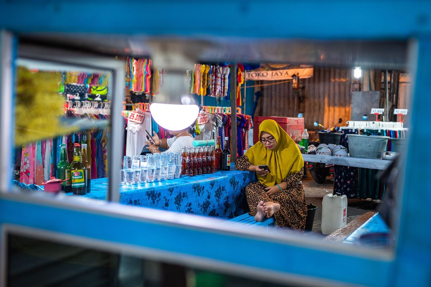 Interior view of a local market shop with blue-tinted shelving and merchandise.