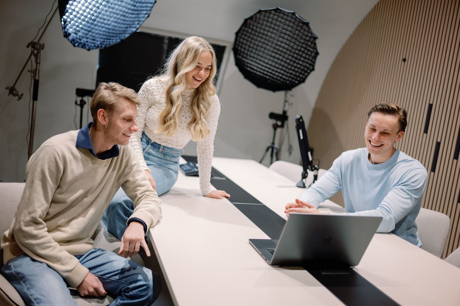 Casual discussion being recorded in a modern podcast studio with professional equipment.