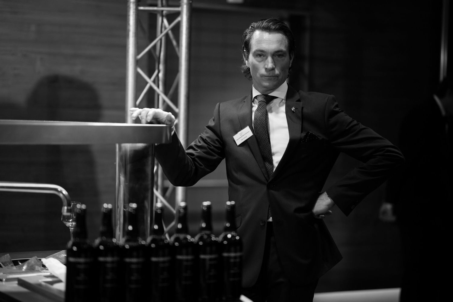 Professional wine tasting event with participants examining glasses in a dark room.