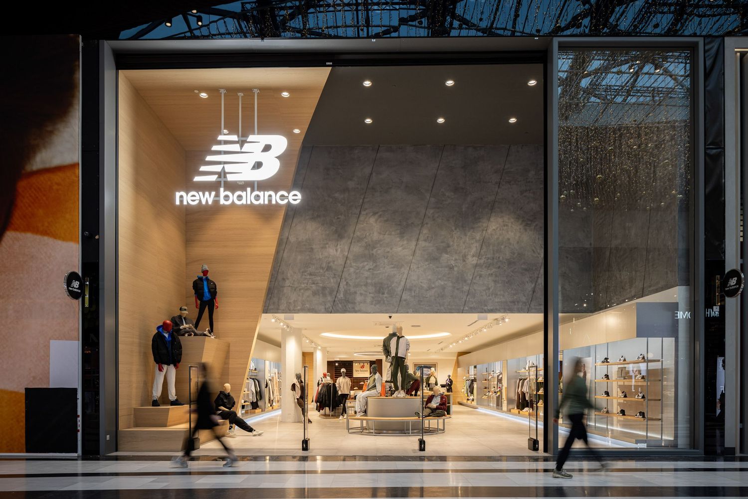 Minimalist New Balance retail storefront with glass windows and modern interior design.
