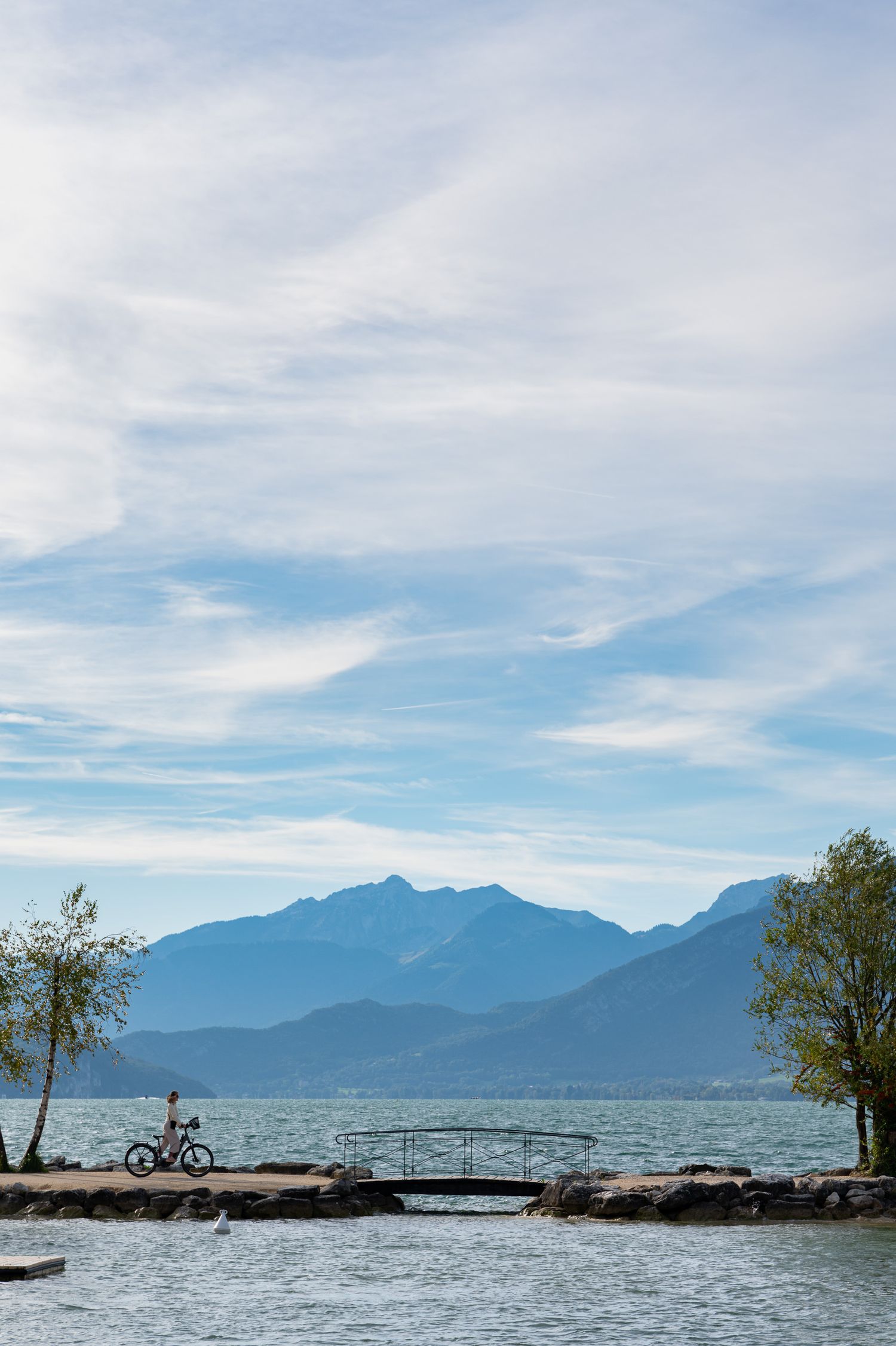 Panoramic view of a mountain lake with a wooden dock and trees along the shoreline.