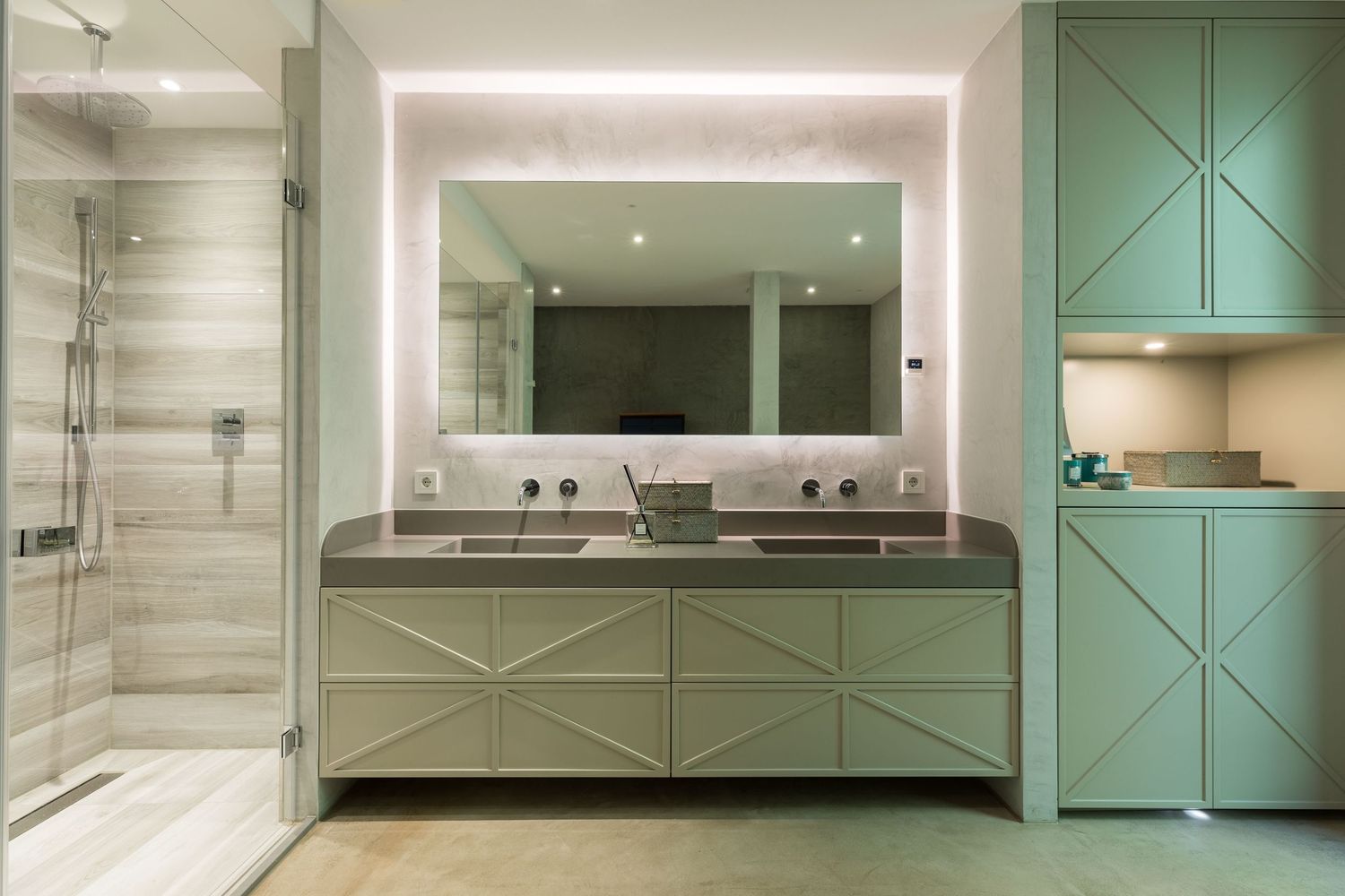 A modern bathroom design featuring mint green cabinets, marble walls, and sleek chrome fixtures creates a spa-like atmosphere.