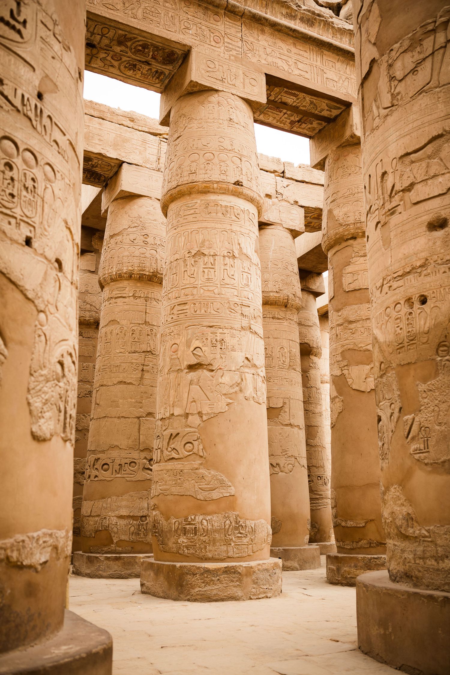 Ancient Egyptian temple interior with massive stone columns covered in hieroglyphic carvings at Karnak.